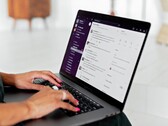 Manos escribiendo en un portátil con una aplicación de chat abierta