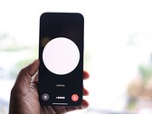 Una mano que sostiene un smartphone con una interfaz de asistente de voz en la pantalla