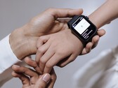 La mano de un adulto colocando un reloj inteligente en la muñeca de un niño