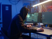 Hacker genérico en una estación de trabajo con dos monitores ejecutando un ataque a la cadena de suministro.