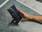 Mano sosteniendo un smartphone con la aplicación ChatGPT abierta sobre una mesa estampada