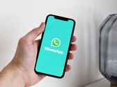 Mano sosteniendo un smartphone con la aplicación WhatsApp abierta