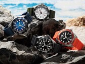 Cuatro relojes de buceo Citizen Promaster Marine en colores blanco, negro, azul y naranja, expuestos sobre unas rocas junto al mar.