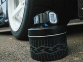 Reloj Casio G-Shock DW5600TT25-1 x Toyo Tires expuesto en una lata metálica con temática de neumáticos junto a una rueda de coche.