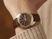 Timex Q 1978 Day and Date con esfera fumé marrón y caja de tono dorado, mostrado en una muñeca con una correa de cuero marrón.