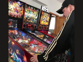 El coleccionista de máquinas de pinball neozelandés Kim Michael Dozier jugando con una máquina de pinball de Iron Maiden en Kimzone