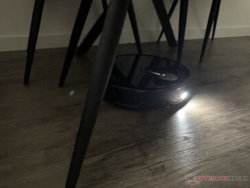 El Roborock Qrevo Slim con la luz encendida en el laberinto de patas de silla